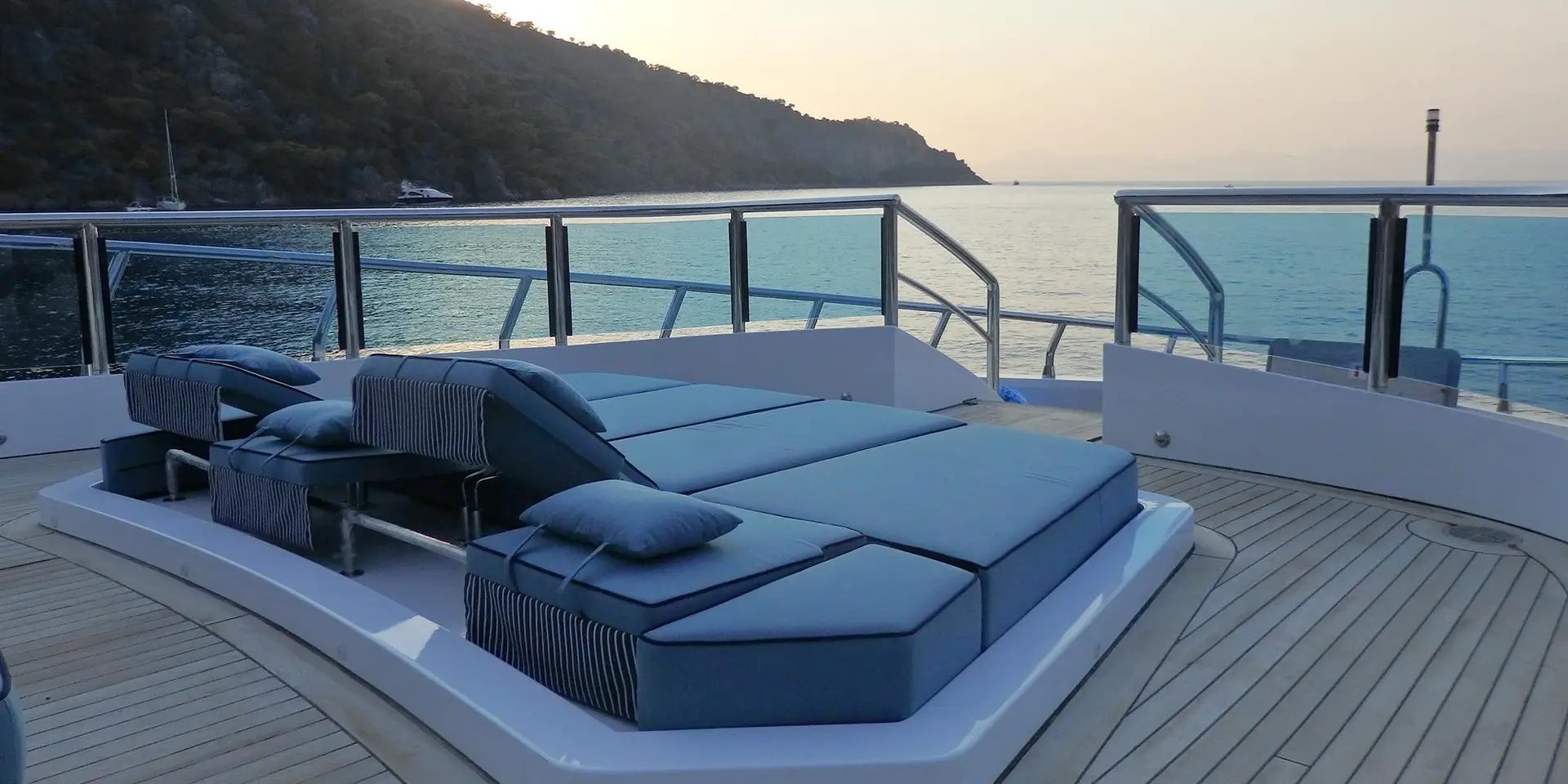 Forward sunbathing area of M/Y DESTINY with blue cushioned loungers